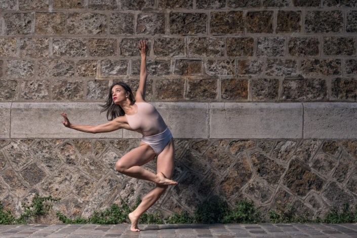 danseuse en mouvement devant un mur en pierre à montmartre