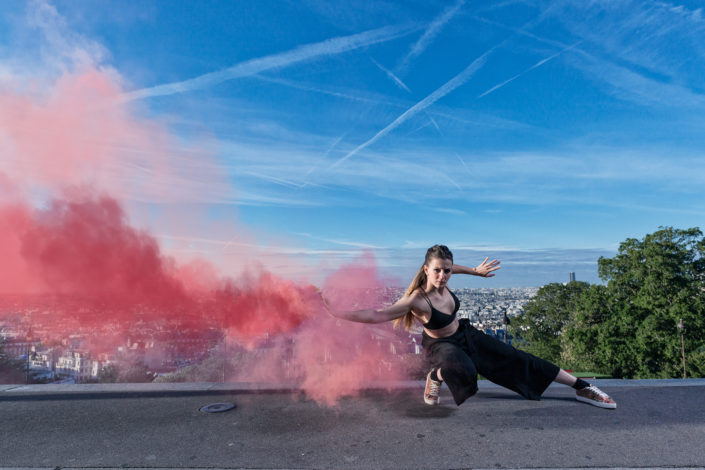 danseuse elodie leborgne avec un fumigene rouge en haut des marches de montmartre