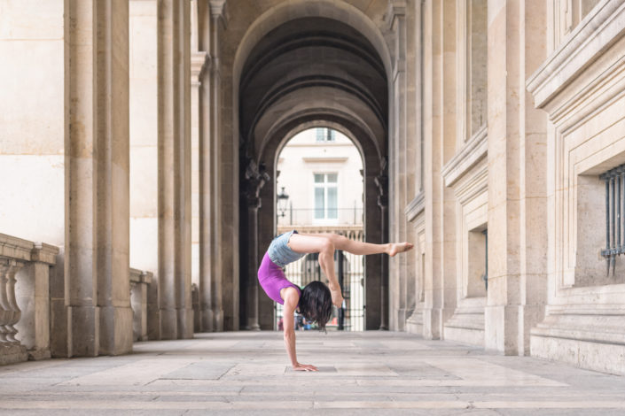 contortioniste en justaucorps rouge dans un passage au louvre