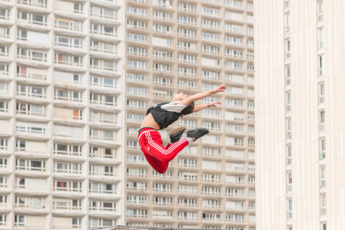 danseuse en levitation davant une barre de batiments