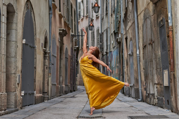 Danseuse en robe jaune dans une ruelle du vieux toulon