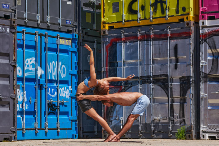 duo de yogi en position à pantin autour de conteneurs